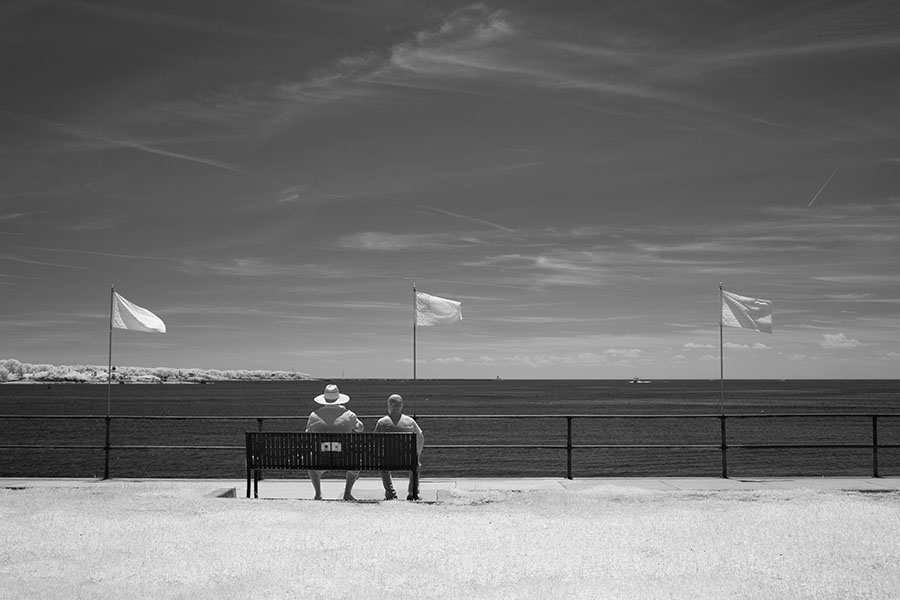 Infrared Photo of Two Men on a Park Bench Overlooking the Outer Harbor of Gloucester, Massachusetts.